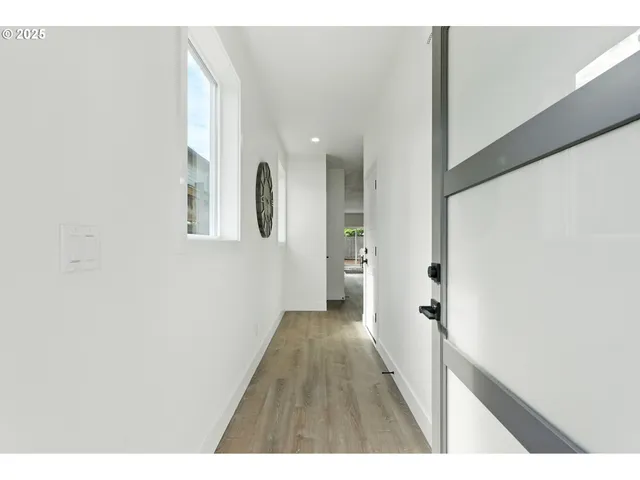 a view of a hallway with wooden floor and staircase