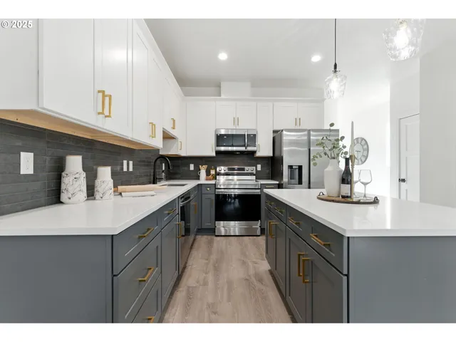 a kitchen with a sink a counter top space stainless steel appliances and cabinets