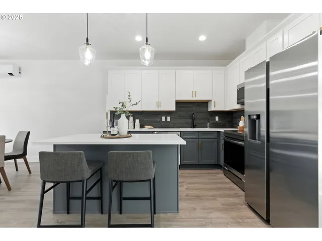 a kitchen with kitchen island granite countertop a sink cabinets and stainless steel appliances
