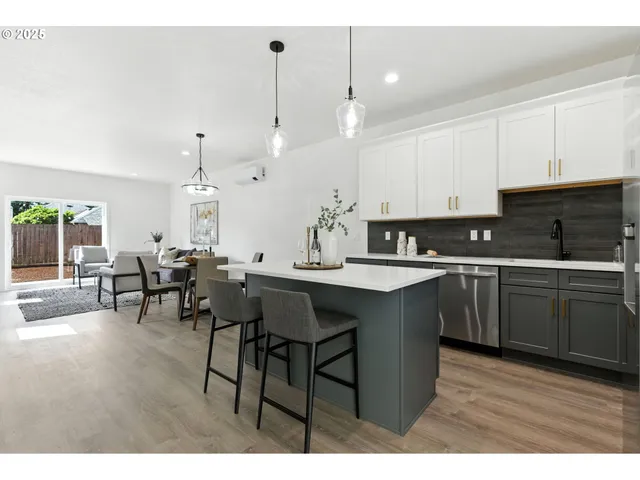 a open kitchen with kitchen island granite countertop a sink cabinets and wooden floor