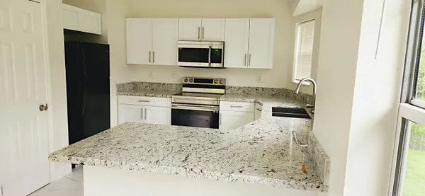 a kitchen with stainless steel appliances granite countertop a stove a sink and a refrigerator