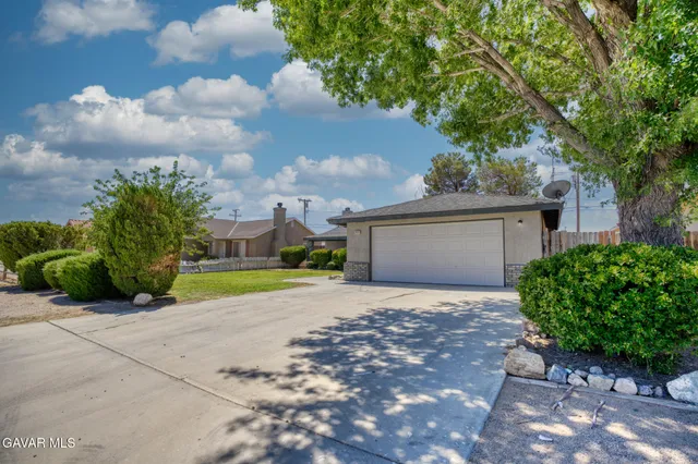 a view of a house with a backyard and a tree