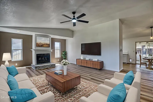 a living room with furniture a flat screen tv and a fireplace