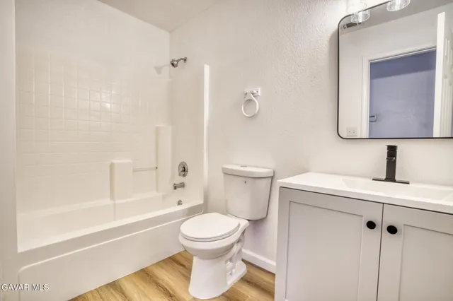a bathroom with a toilet sink a mirror and bathtub