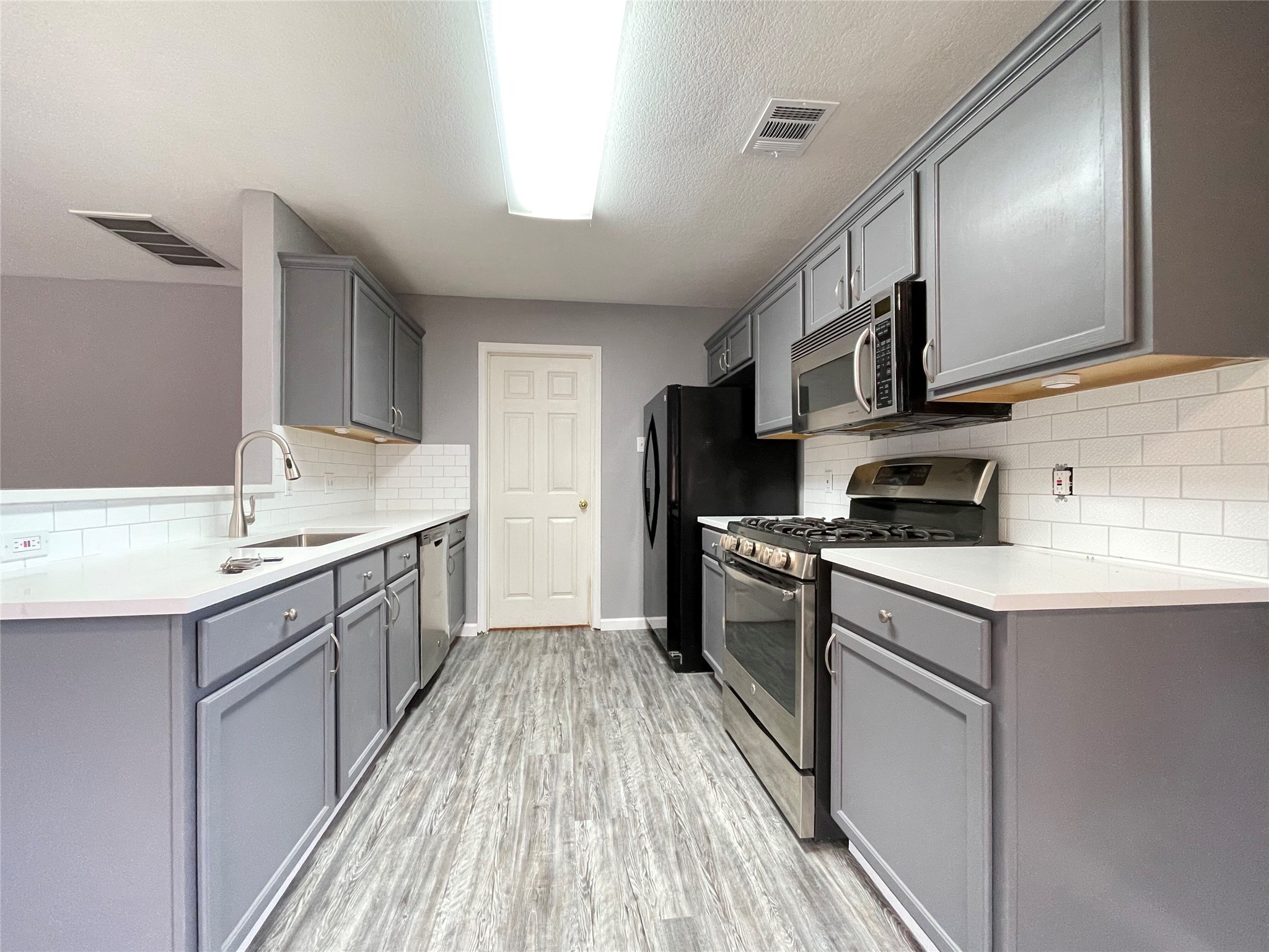 3638 Windhill Loop Round Rock, TX 78681 - Photo 11 of 32 Well-appointed kitchen featuring light gray cabinetry, white countertops, white subway tile backsplash, and stainless steel appliances