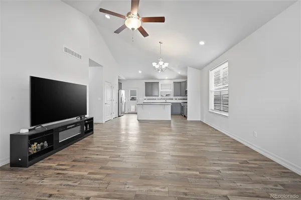 a large kitchen with stainless steel appliances granite countertop a stove a sink a refrigerator and a granite countertops with wooden floor
