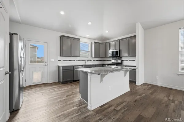 a kitchen with granite countertop a stove top oven and cabinets
