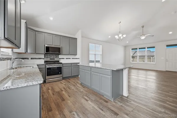 a kitchen with stainless steel appliances a stove a microwave and sink