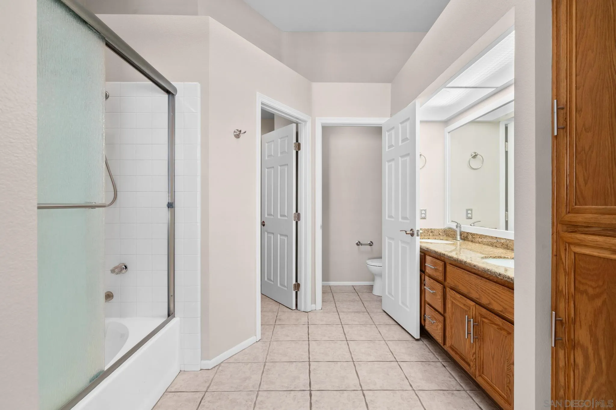 9338 Babauta Road, Unit 78 San Diego, CA 92129 - Photo 16 of 26 a bathroom with a double vanity sink a toilet and shower