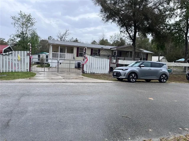 a front view of a house with cars parked on road