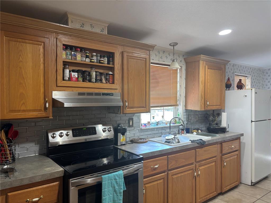 203 Vancouver Circle Interlachen, FL 32148 - Photo 24 of 25 a kitchen with stainless steel appliances granite countertop a sink stove and refrigerator