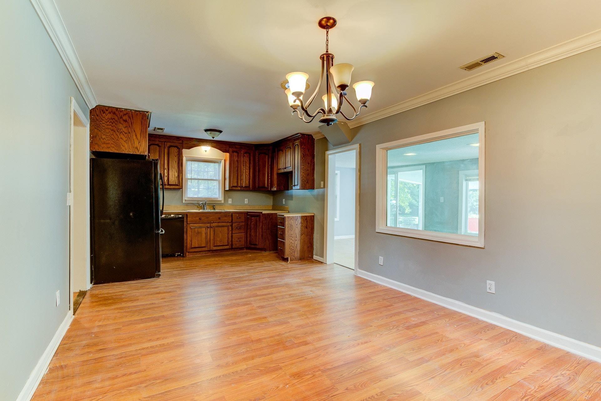 5028 Henry Road Henry, VA 24102 - Photo 20 of 44 a kitchen with stainless steel appliances granite countertop a refrigerator a sink dishwasher a stove and a dining table with wooden floor