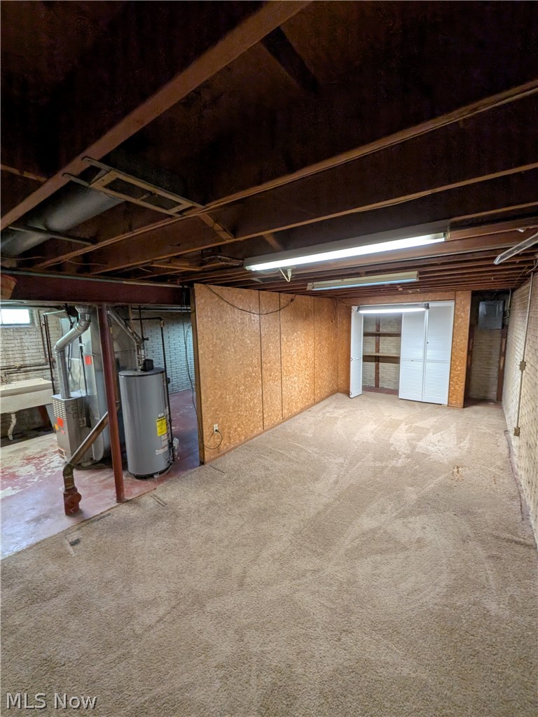 1161 Gulf Road Elyria, OH 44035 - Photo 27 of 34 Carpeted lower-level space with paneling, exposed ceiling joists, and fluorescent lighting