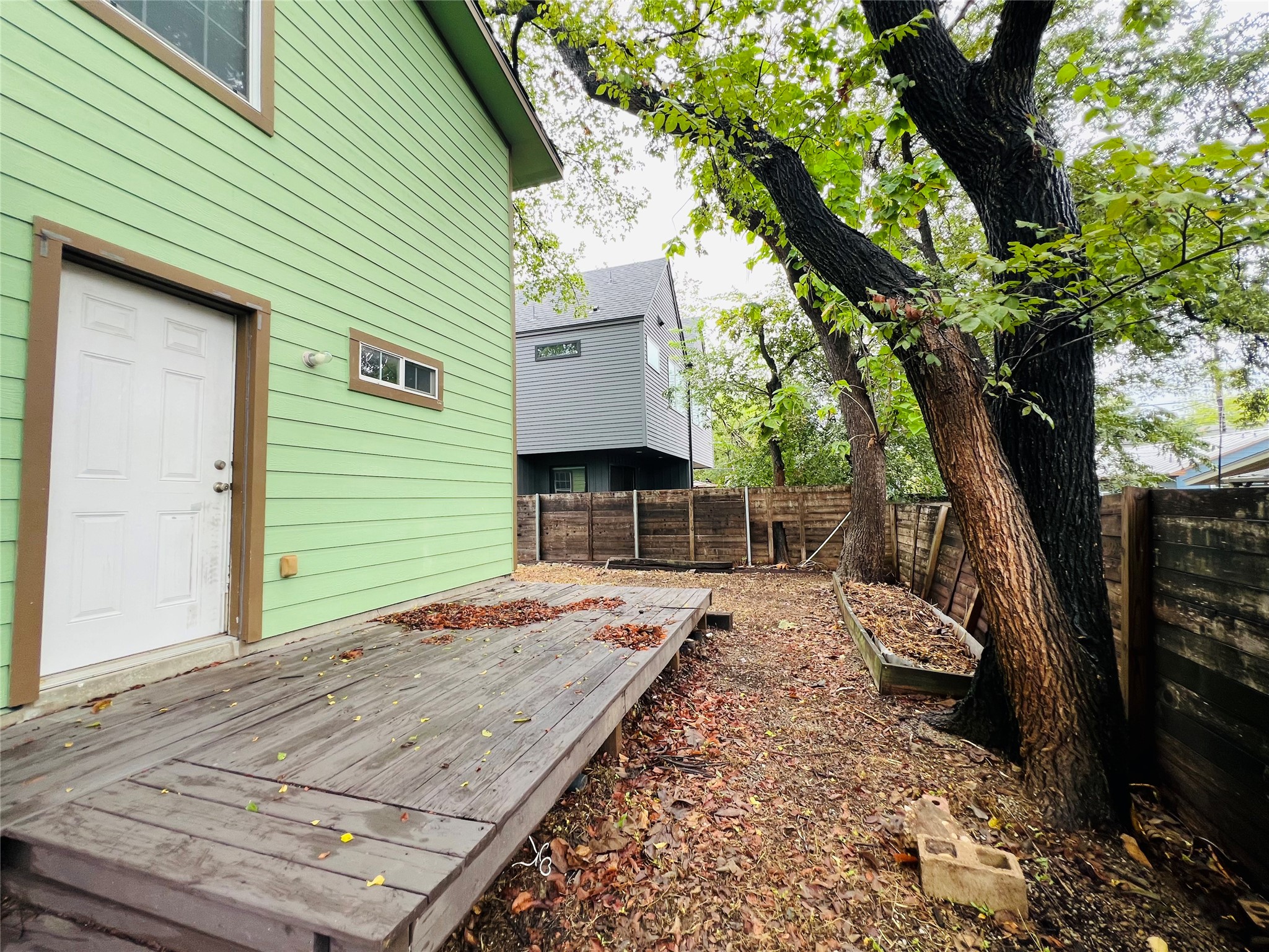 2409 Santa Rosa Street Austin, TX 78702 - Photo 27 of 27 Mature trees shade a private wooden deck and fenced backyard space.