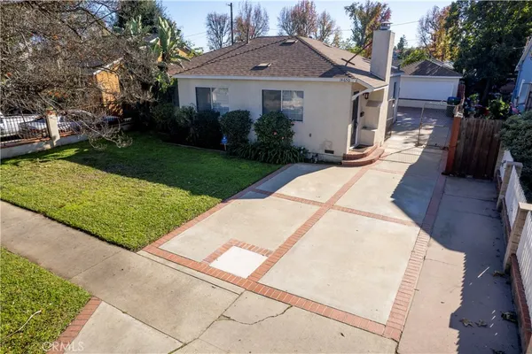 a front view of a house with a yard and potted plants