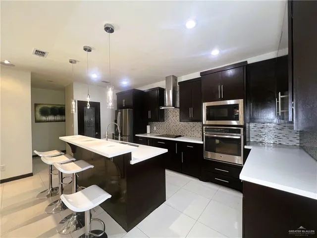 a kitchen with stainless steel appliances kitchen island granite countertop a sink and cabinets