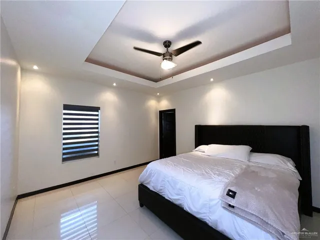 a bedroom with a bed and a large mirror