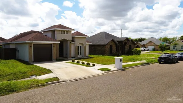a view of a house with a big yard and large trees