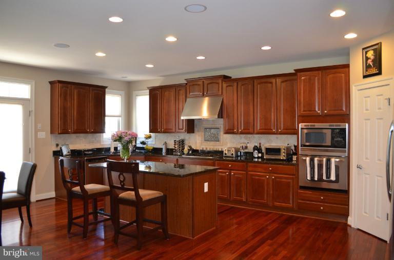 10850 Nemrod Road Perry Hall, MD 21128 - Photo 13 of 25 a kitchen with granite countertop wooden floors and wooden cabinets