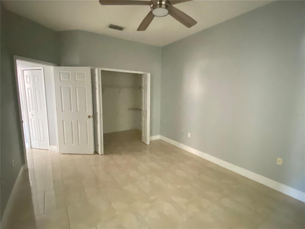 2467 Huron Circle Kissimmee, FL 34746 - Photo 12 of 26 an empty room with a ceiling fan and carpet