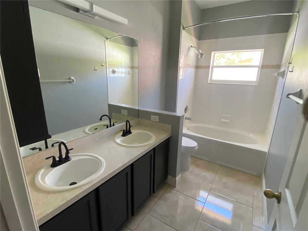 2467 Huron Circle Kissimmee, FL 34746 - Photo 13 of 26 a bathroom with a sink and a mirror