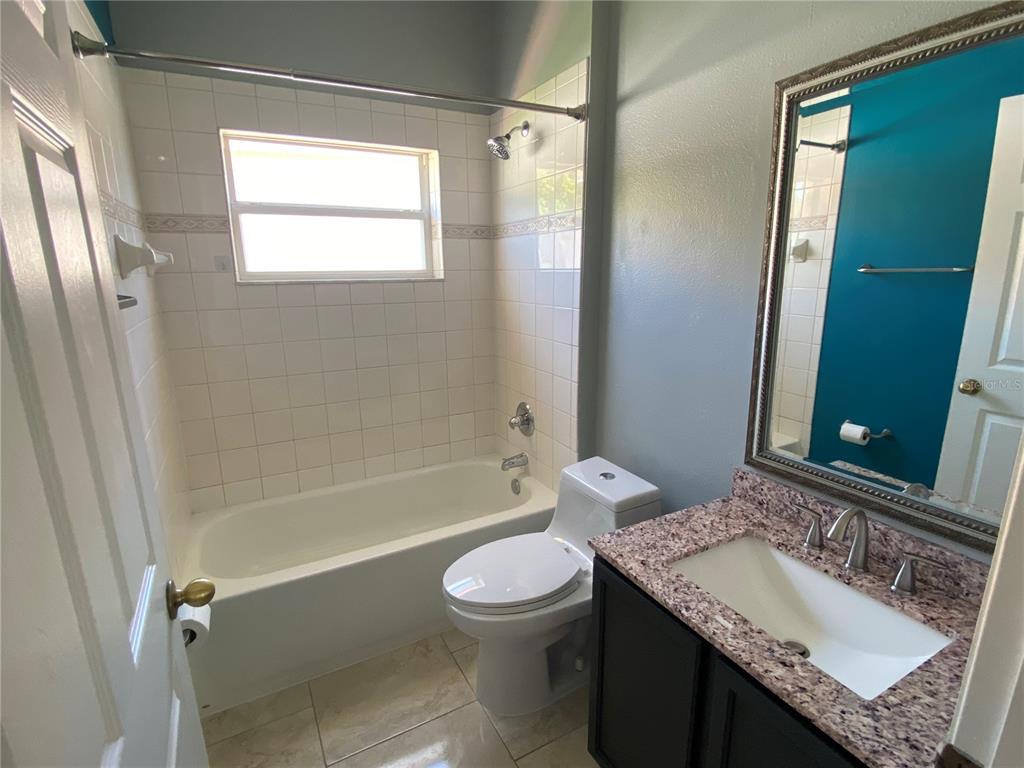 2467 Huron Circle Kissimmee, FL 34746 - Photo 16 of 26 a bathroom with a granite countertop sink toilet and shower