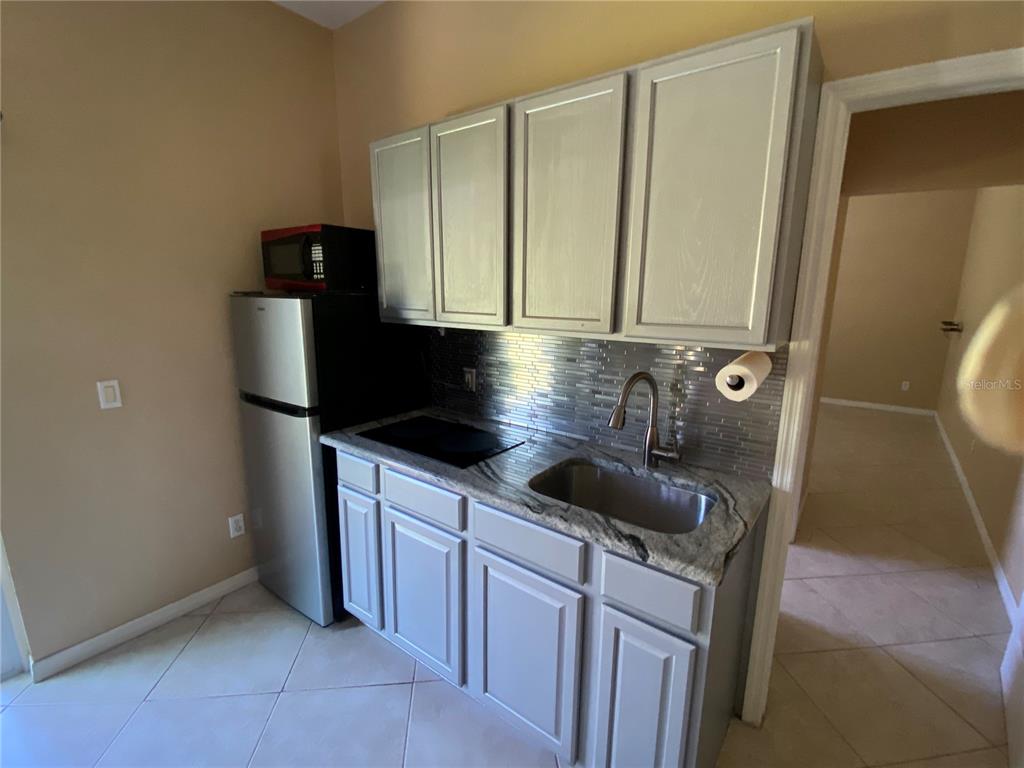 2467 Huron Circle Kissimmee, FL 34746 - Photo 20 of 26 a kitchen with stainless steel appliances granite countertop a sink stove and refrigerator