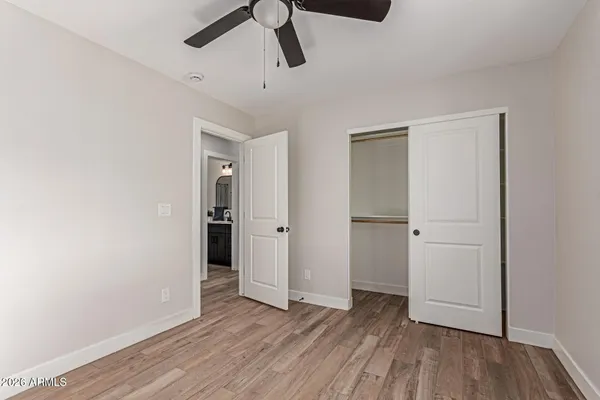 an empty room with wooden floor cabinet and windows