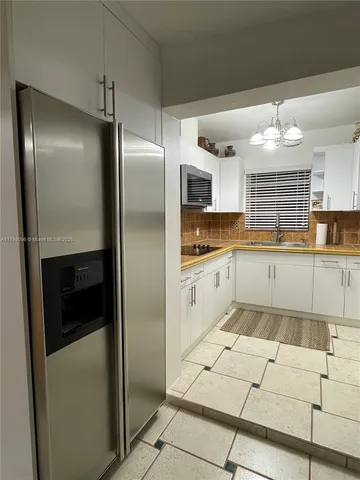 a kitchen with granite countertop a refrigerator and a sink