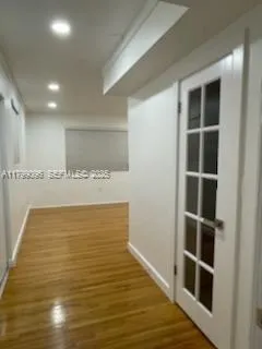 a view of an empty room with wooden floor and closet