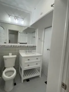 a bathroom with a granite countertop toilet a sink and a mirror