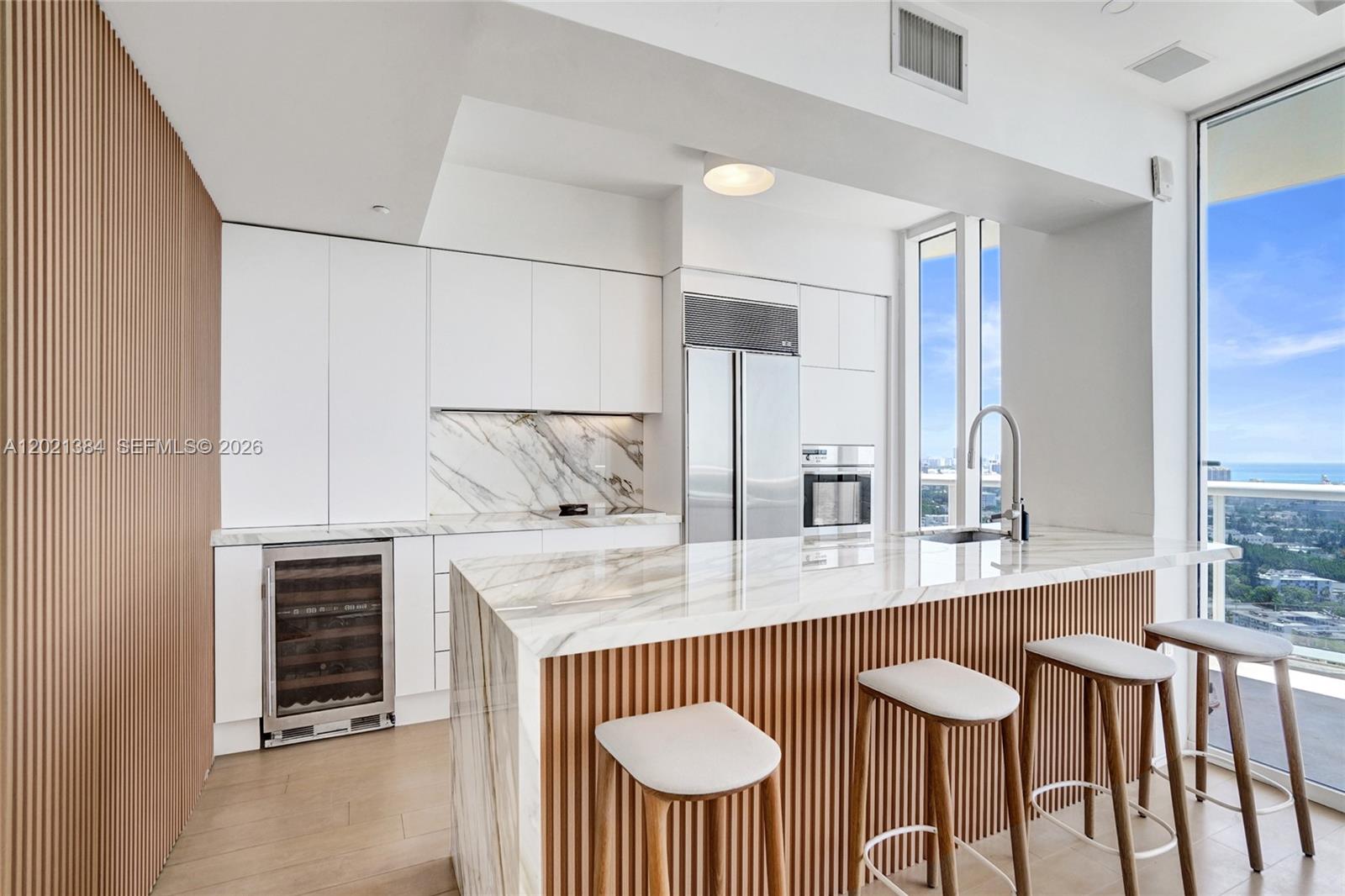 400 Alton Road, Unit PH11 Miami Beach, FL 33139 - Photo 9 of 49 a kitchen with stainless steel appliances a sink and a table