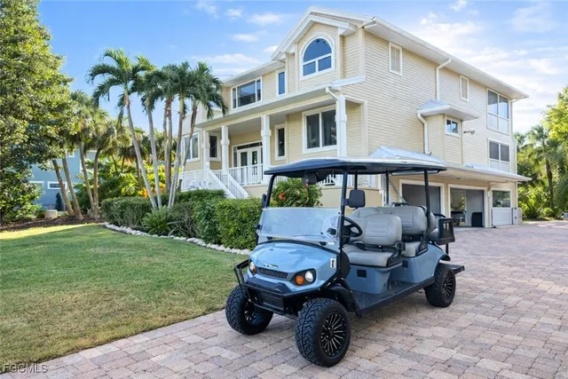 a view of a white house with a big yard and large trees