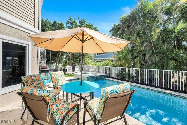 a view of a patio with a table chairs and a swimming pool