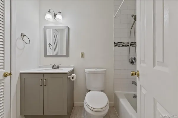 a bathroom with a toilet a sink a mirror a vanity and shower