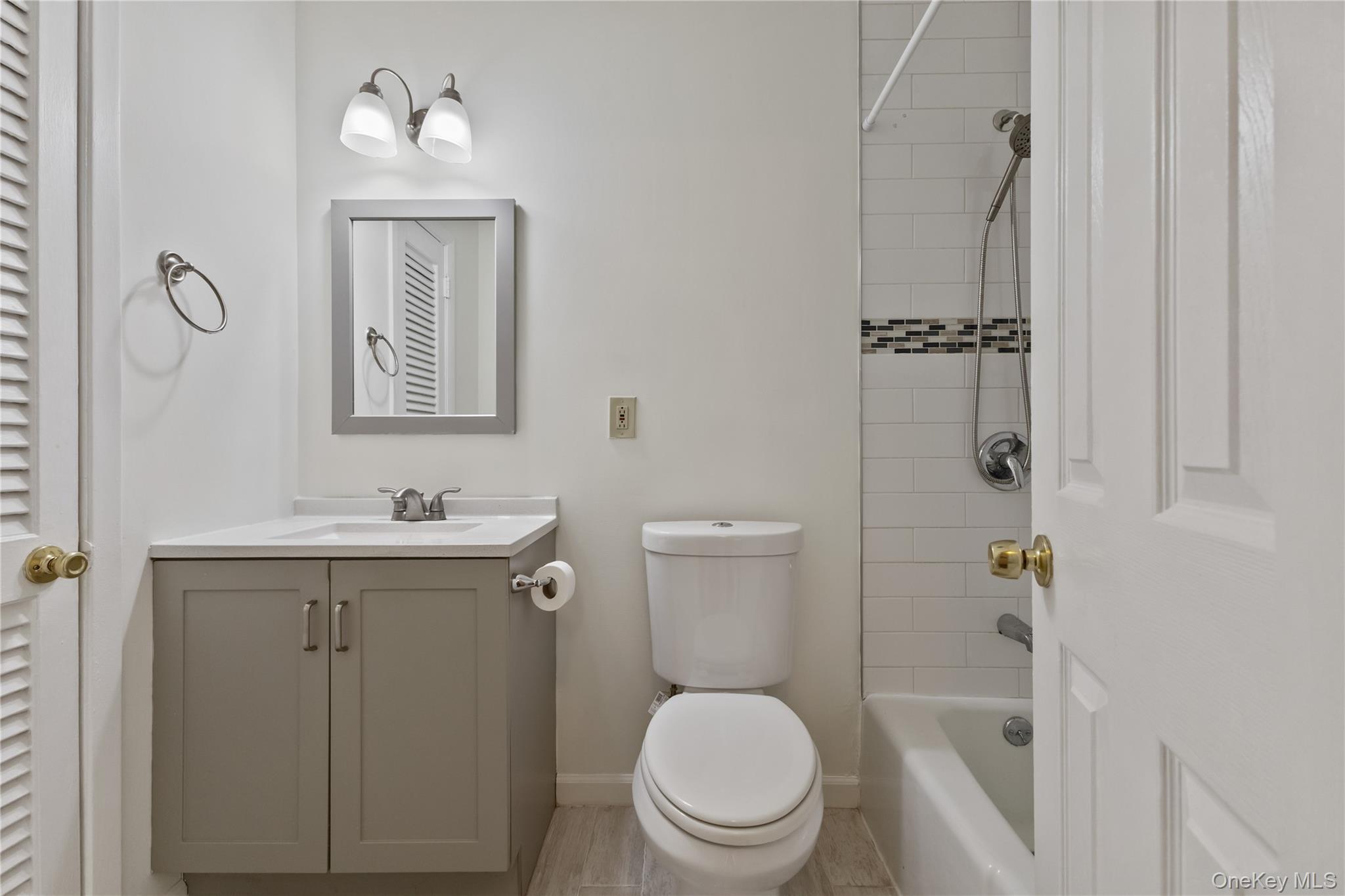 8 North James Street, Unit G Peekskill, NY 10566 - Photo 17 of 25 a bathroom with a toilet a sink a mirror a vanity and shower