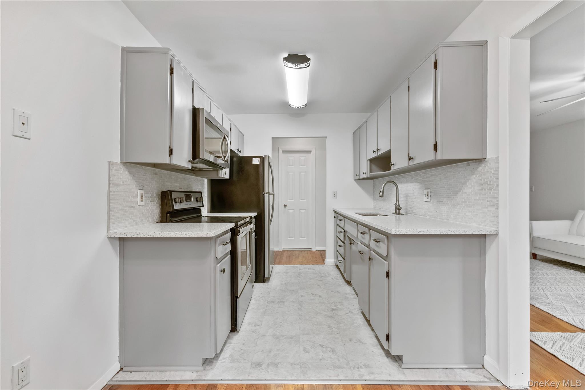 8 North James Street, Unit G Peekskill, NY 10566 - Photo 10 of 25 a kitchen with kitchen island granite countertop a sink a counter space stainless steel appliances and cabinets