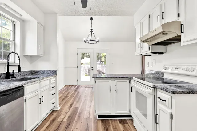 a kitchen with stainless steel appliances granite countertop a sink stove and cabinets