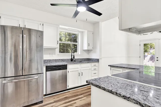 a kitchen with stainless steel appliances granite countertop a sink stove and refrigerator