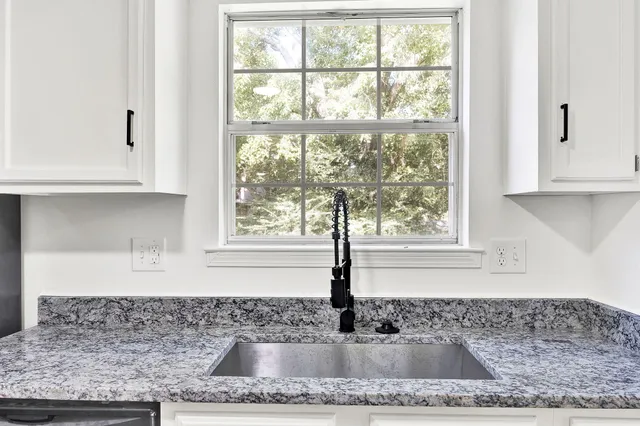 a kitchen with granite countertop a sink and a window