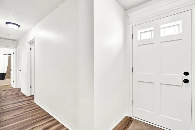 a view of a hallway with wooden floor and closet