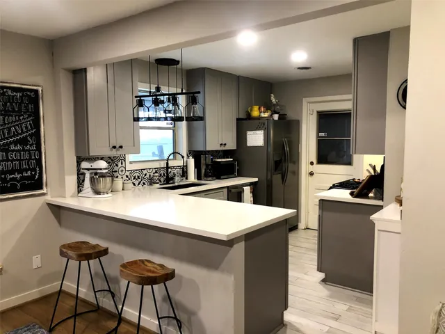 a kitchen with a sink a stove and chairs