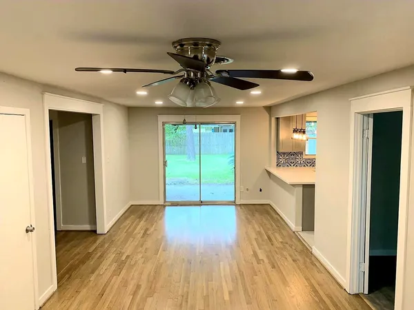 a very nice looking room with wooden floor and a ceiling fan