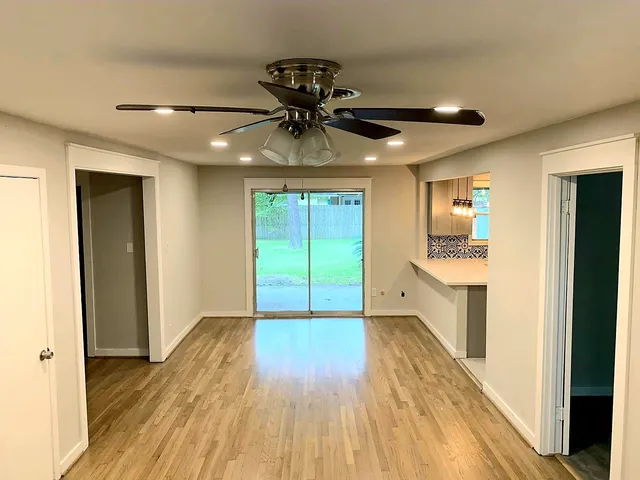 a very nice looking room with wooden floor and a ceiling fan