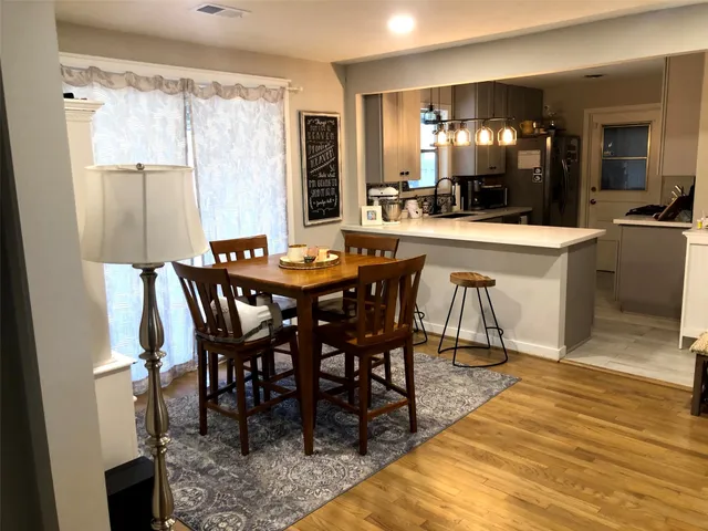 a dining hall with stainless steel appliances a table and chairs
