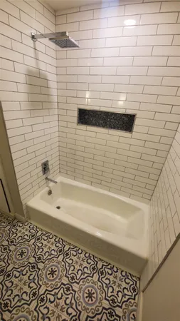 a bathroom with a bathtub and shower