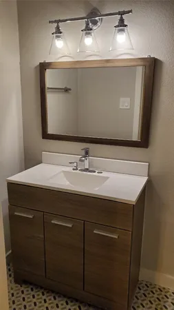 a bathroom with a sink vanity and mirror