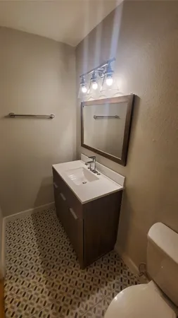 a bathroom with a sink toilet and mirror