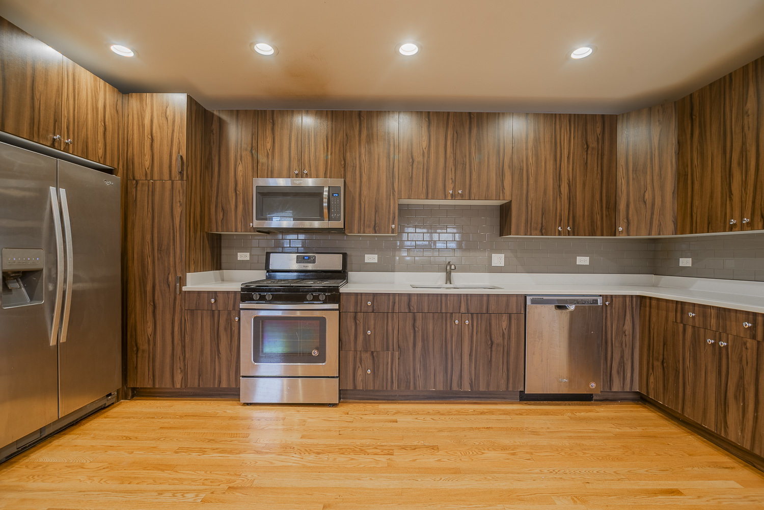 3433 South Indiana Avenue, Unit 301 Chicago, IL 60616 - Photo 2 of 12 a kitchen with kitchen island granite countertop wooden cabinets a refrigerator and a sink