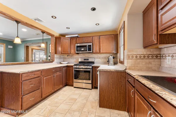a kitchen with stainless steel appliances granite countertop a stove sink and cabinets